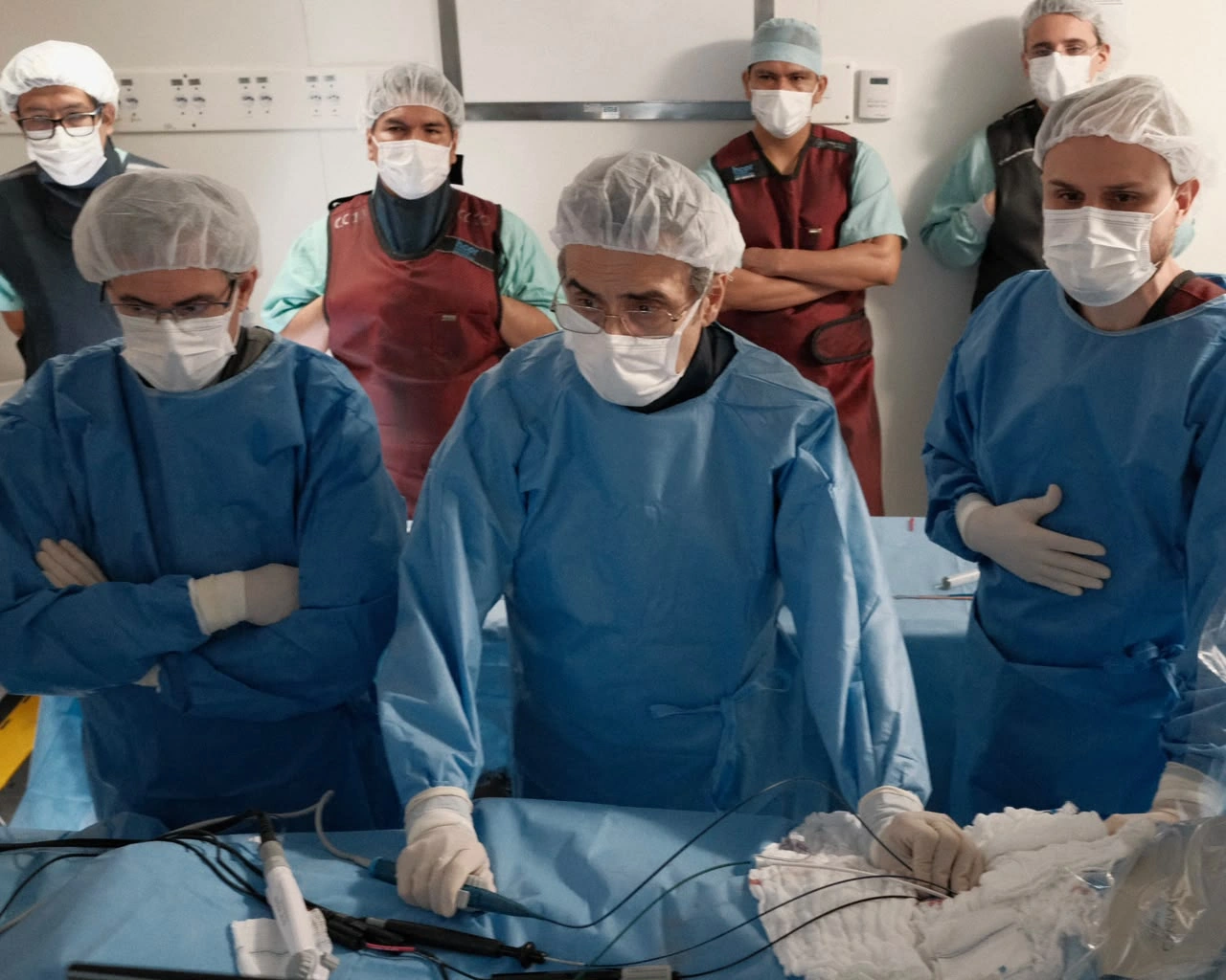 Dr. José Carlos Pachón ao centro, manipulando o cateter durante ablação de fibrilação atrial, acompanhado por sua equipe.